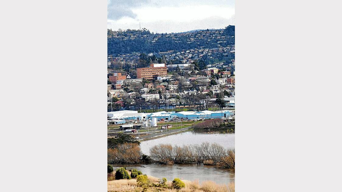 The North Esk River in flood, with Becks Hardware and the QV building in the background.