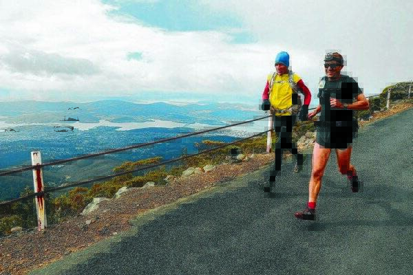 Runners John Kent and Andrew Kromar run down Mount Wellington on their way to the finish line.  Picture: PAUL SCAMBLER
