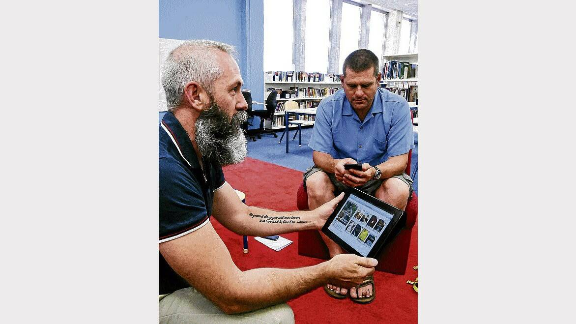 LINC manager Garry Conroy-Cooper and e-book reader Alan King, of South Launceston. Mr King reads e-books on his android phone. Picture: NEIL RICHARDSON
