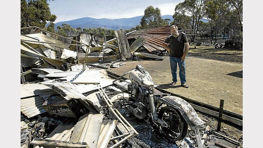 Mal Murdock surveys the damage to his property at Dunalley. His house was saved, but he lost a Harley-Davidson motorcycle, a speedboat and a Holden Monaro. Picture: PAUL SCAMBLER