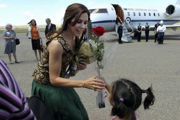 Denmark's Crown Princess Mary accepts a rose from a young girl as she farewells the crowd at Broken Hill airport.