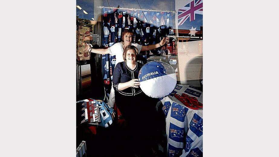 Sheree Evans (back) and Lucille Stubbs decorate the window display for Australia Day at Winflo Curtains. Picture: GEOFF ROBSON