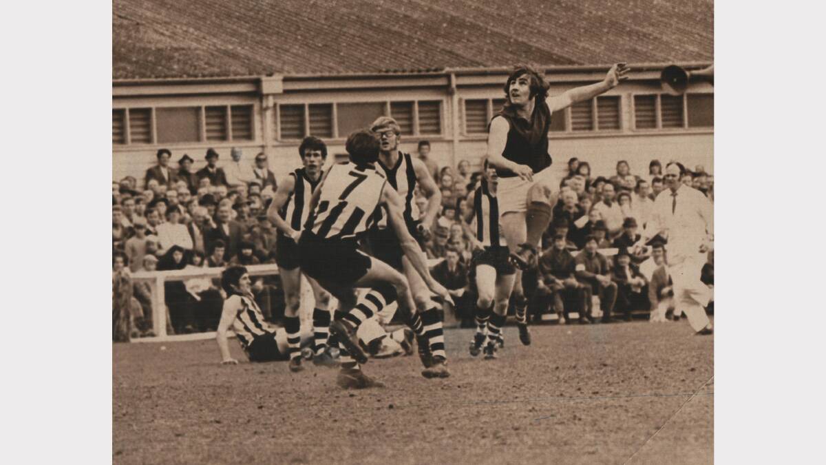 Scottsdale's Bob Wilson, Leon Ranson and Les Lette watch on as Latrobe player Denis Smith kicks for goal. State football pre-final, York Park, 1971.