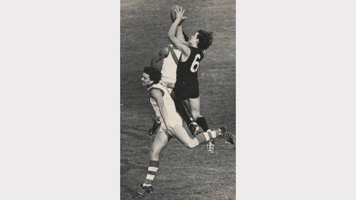 Launceston player Craig Davis marks over City-South's Paul Hogan and Derek Peardon during the final game of the lightning football premiership at York Park, 1973.