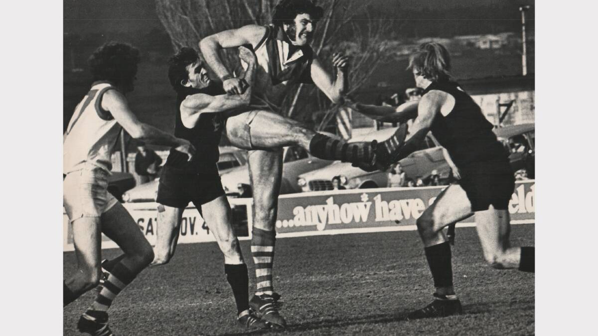 Launceston's Alby Dunn tackles City-South's Bill Fotheringham, watched on by City-South's Wayne Chugg and Launceston's David Nash. Semi-final at York Park, 1973