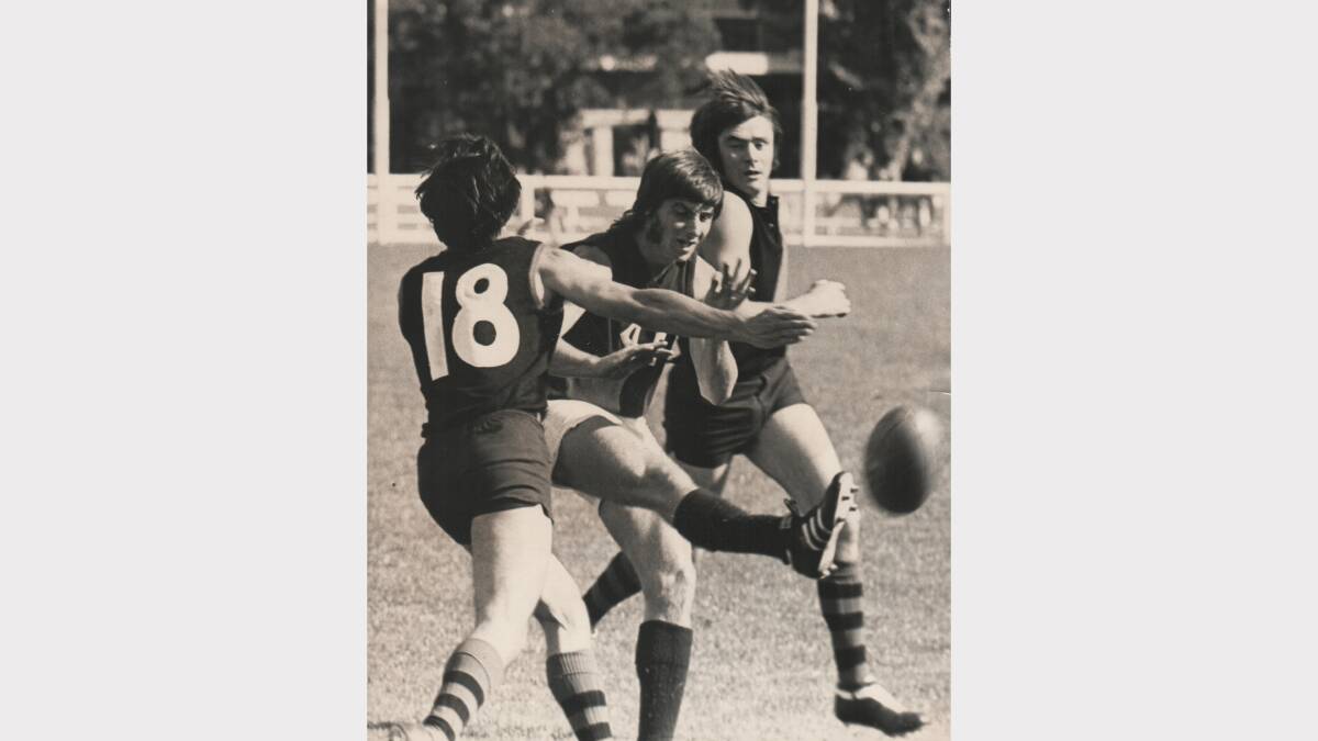 Philip Patterson, of Launceston, shoots for goal as two North Launceston players try to spoil his kick. 1973.