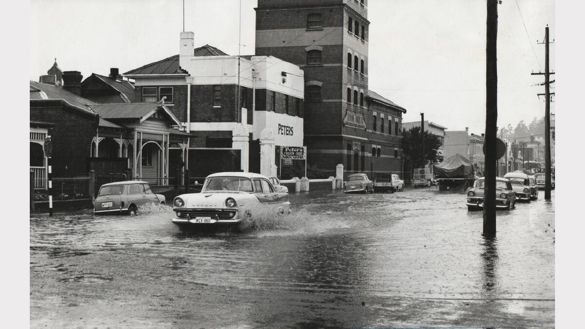A car drives through almost 18 inches of water on the corner of York and Bathurst streets. February 12, 1964.