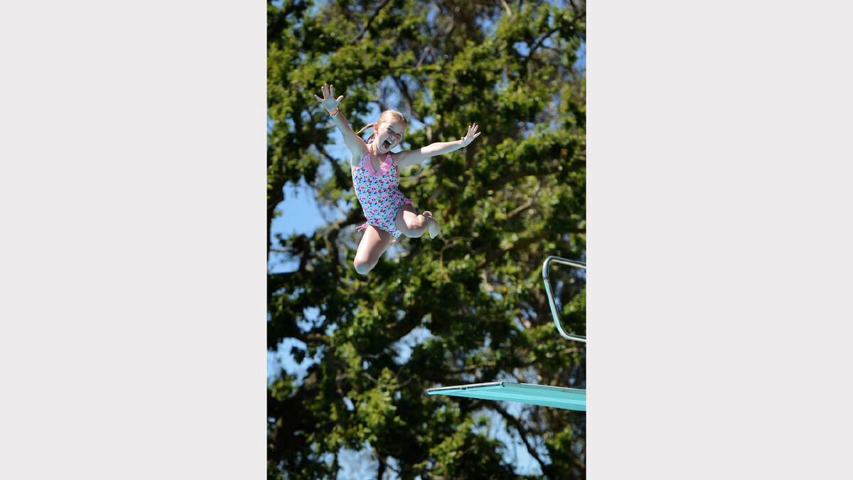 Ella Tuit, 8, leaps for joy and into the pool. Picture: Scott Gelston