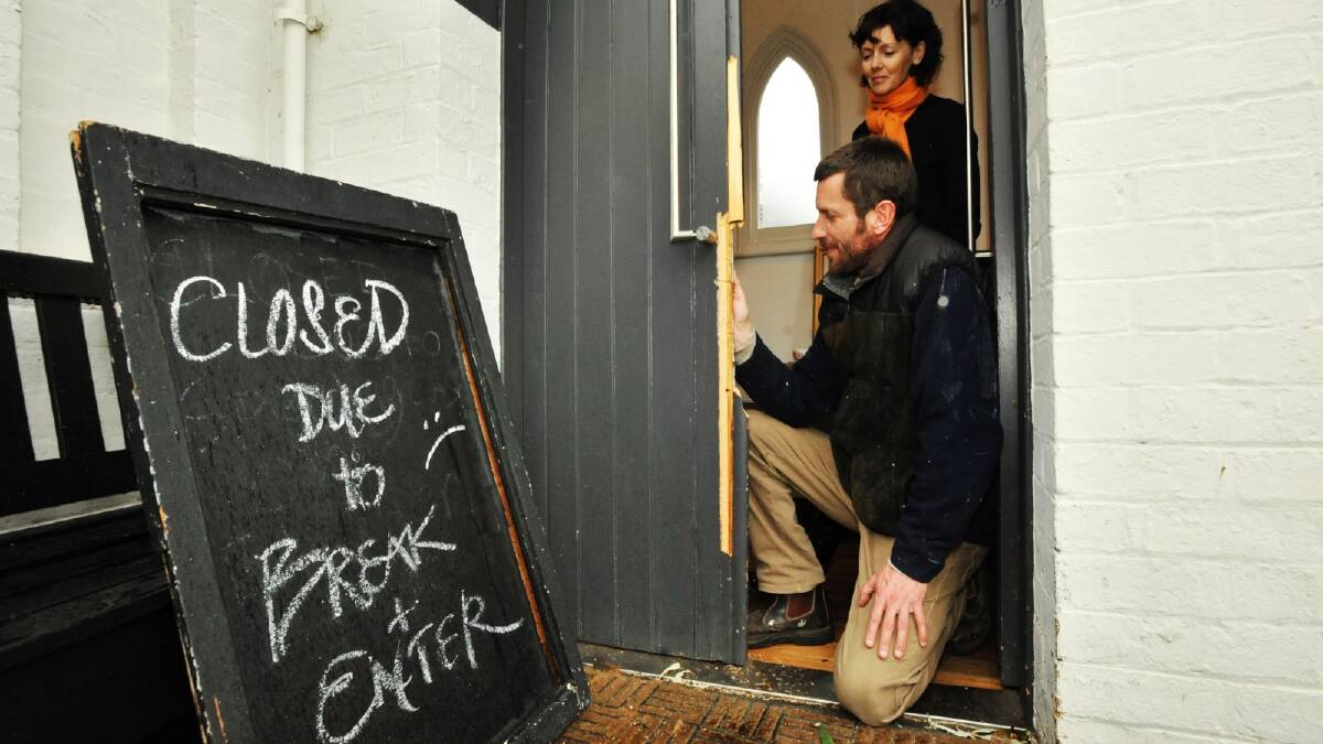 Ut si cafe's Colette Barnes and furniture maker and restorer James Curtis look over the 175-year-old doors that were damaged during a break-in.