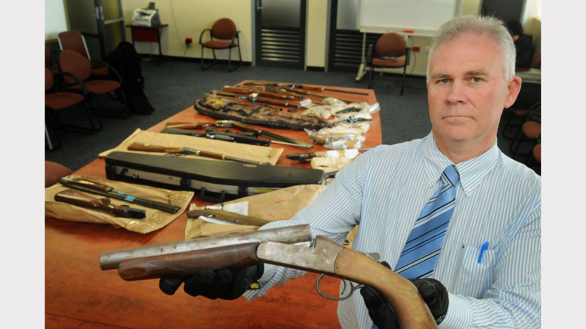 Detective Inspector Scott Flude with firearms seized by police.