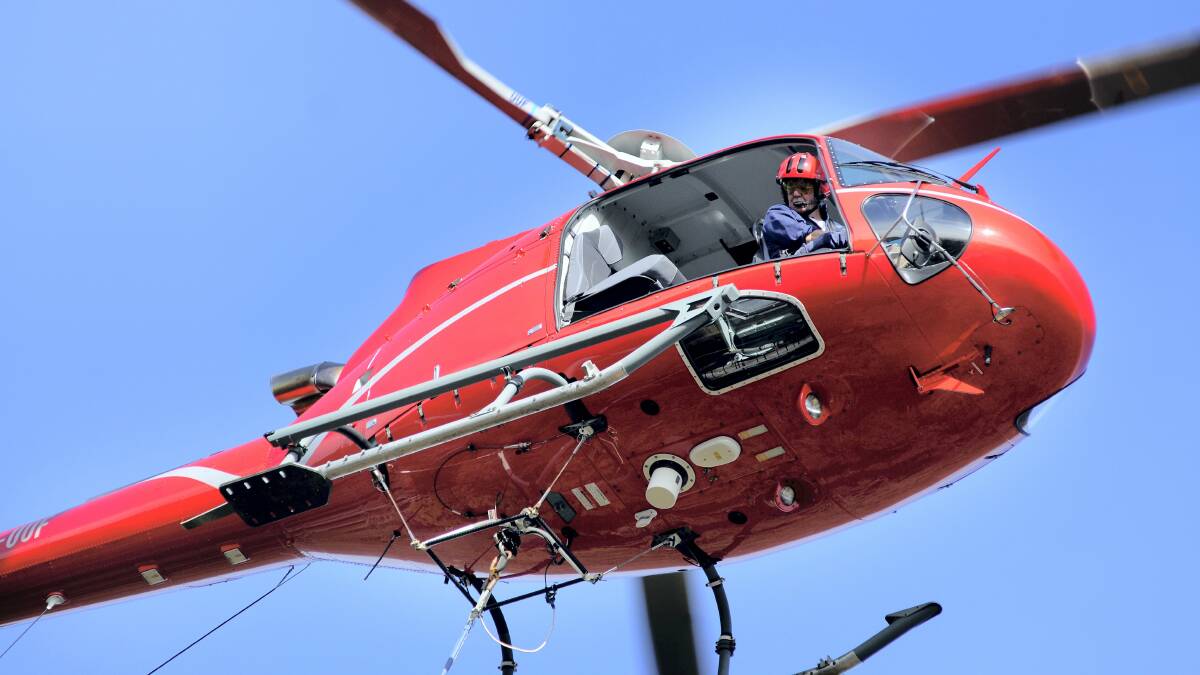 Chopper pilot Frank Ross manoeuvres his helicopter into the Cataract Gorge yesterday, to deliver parts of the new cantilevered lookout.   Picture: GEOFF ROBSON