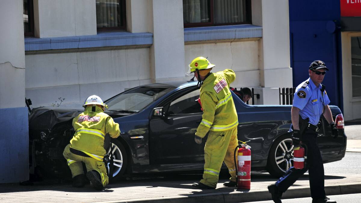 Firefighters inspect the stolen Holden Commodore ute that was crashed into the corner of the C. H. Smith Building in Launceston yesterday.  Picture: PHILLIP BIGGS  