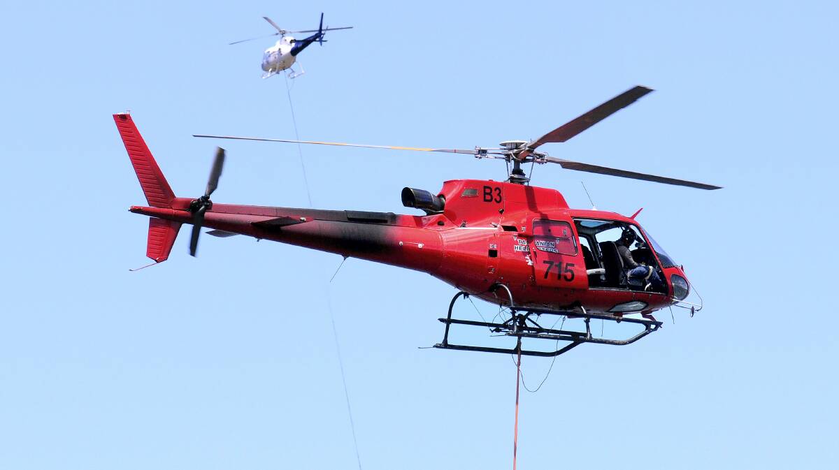Water bombing helicopters refill with water at Cramps Bay at   Great Lake yesterday. 