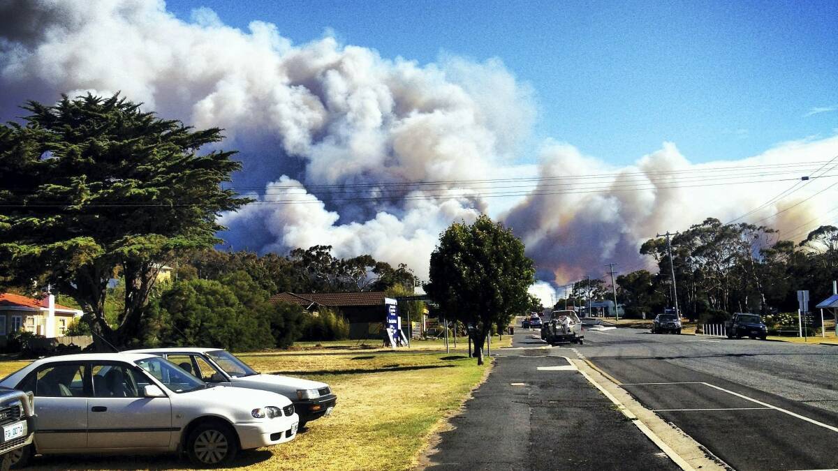 Smoke hangs over Bicheno from a blaze threatening the area yesterday. Picture: HANNAH WOOLLEY  