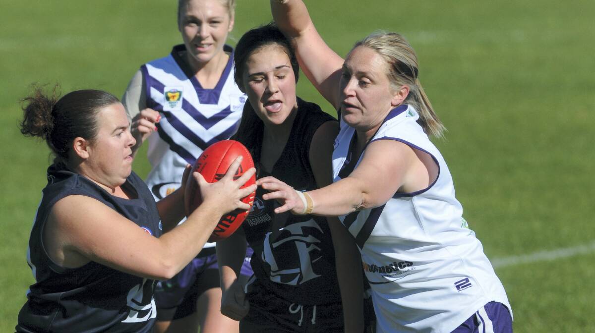  Launceston's  Kylie Bramich  tries to get away with the ball in front of  teammate  Allyssa Czylok and  Burnie's  Danika Corcoran.  Picture: PAUL SCAMBLER.