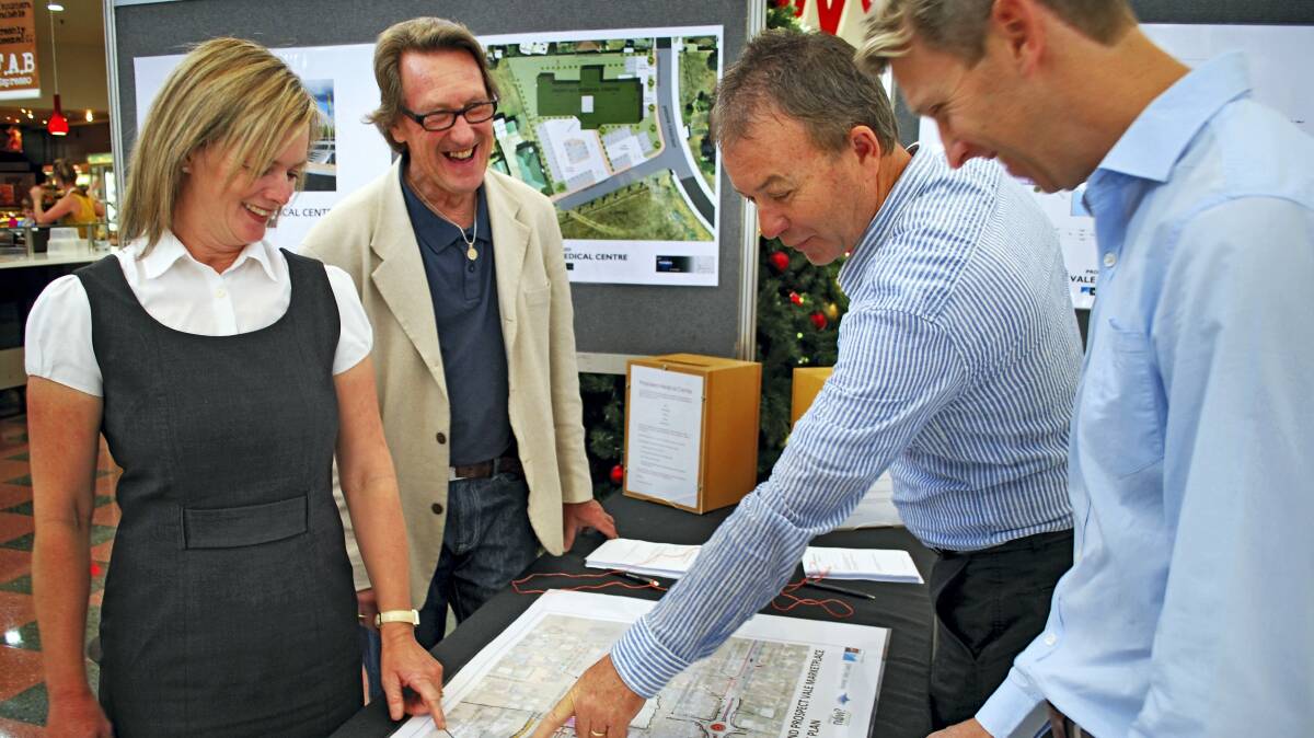 Vos Family Office executive assistant Rebecca Johnson, architect Lez Penzes, Vos Family Office chief executive David Gray and GHD planner Ashley Brook inspect newly released plans for a Prospect Vale Marketplace medical centre.