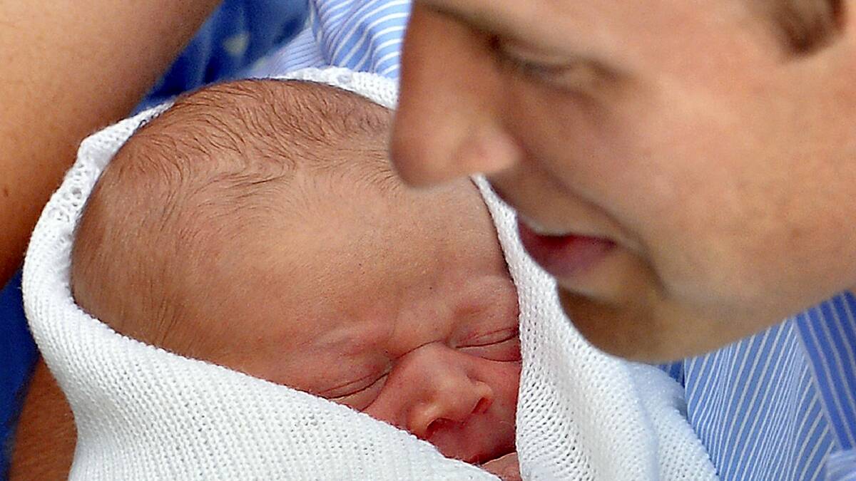 Prince William holds his baby son, wrapped in a white shawl made from Australian merino wool.