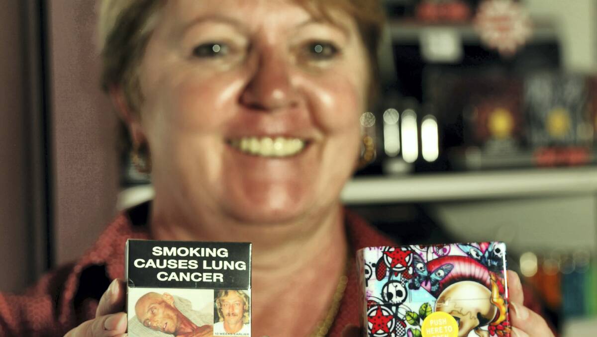 Sharon Wade, of Free Choice Tobacconist, Launceston, with a plain cigarette pack on the left, and a cigarette case.  