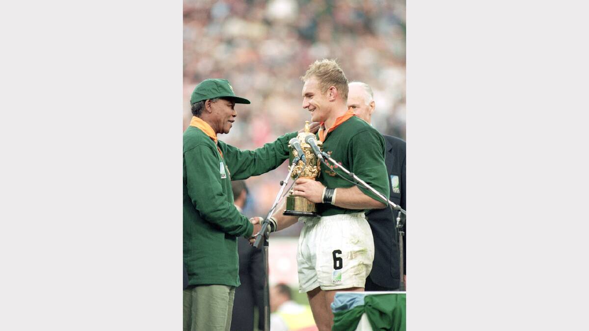 Francois Pienaar of South Africa receives the William Webb Ellis Trophy from President Nelson Mandela after the Rugby World Cup final between South Africa and New Zealand held on June 24, 1995 at Ellis Park in Johannesburg, South Africa. South Africa won the match 15-12.