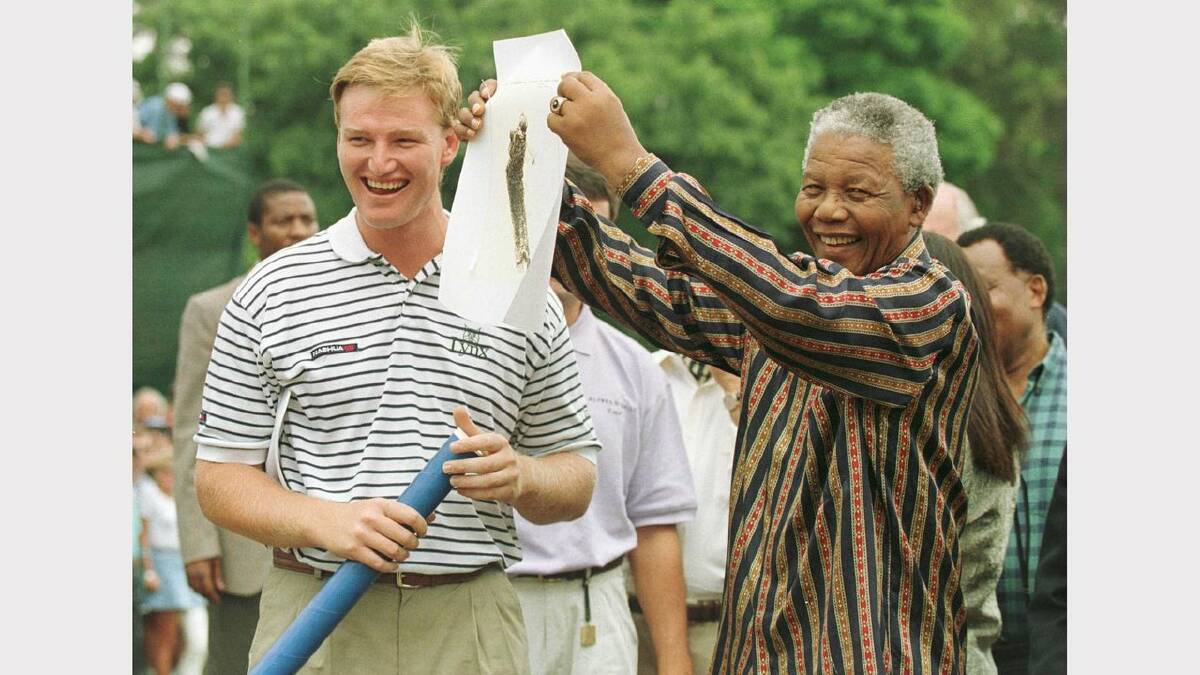 18 Feb 1996:  Ernie Els and President Nelson Mandela of South Africa share a laugh as Mandela shows a sketching of Els to the crowd before the final round of the Alfred Dunhill South African PGA Championship at Houghton Golf Club, Johannesburg, South Africa. Mandatory Credit: Allsport UK/Allsport	