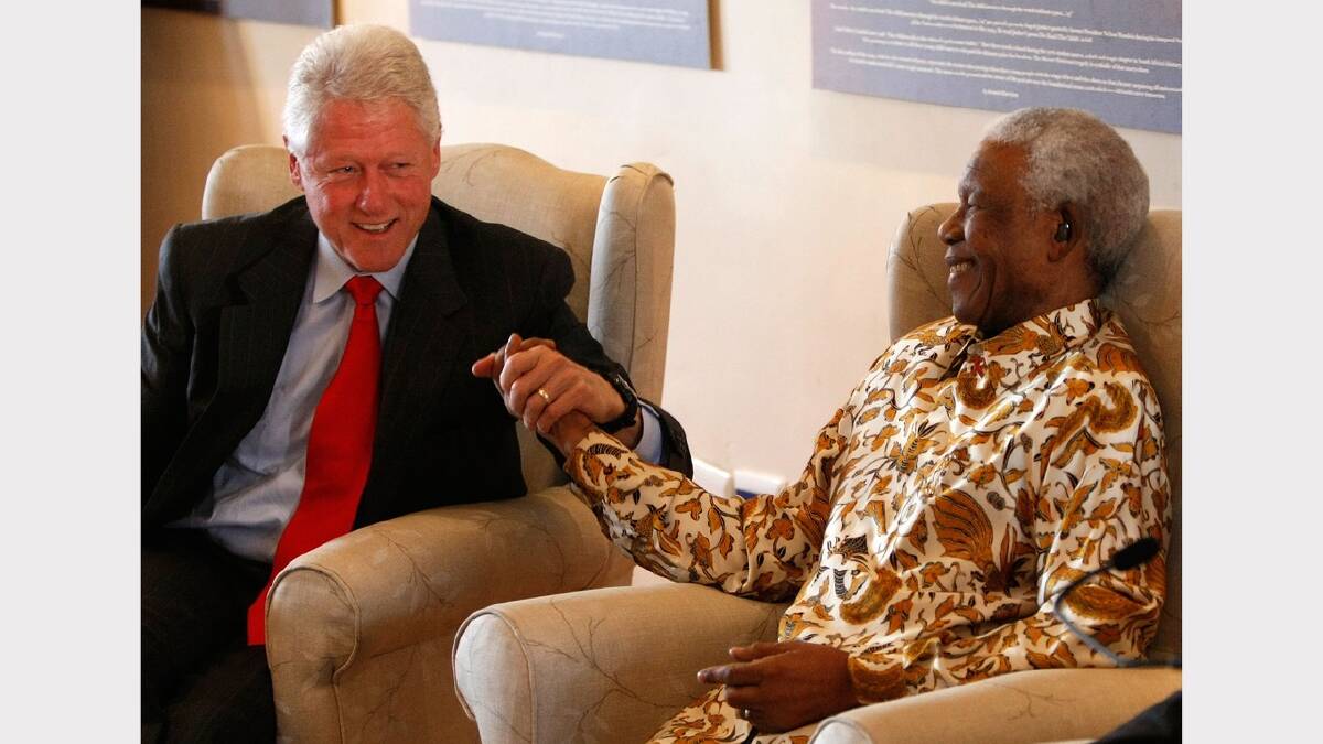 Former U.S. President Bill Clinton (L) embraces former South African President Nelson Mandela following remarks by Clinton during a visit to the Nelson Mandela Foundation July 19, 2007  in Johannesburg. 