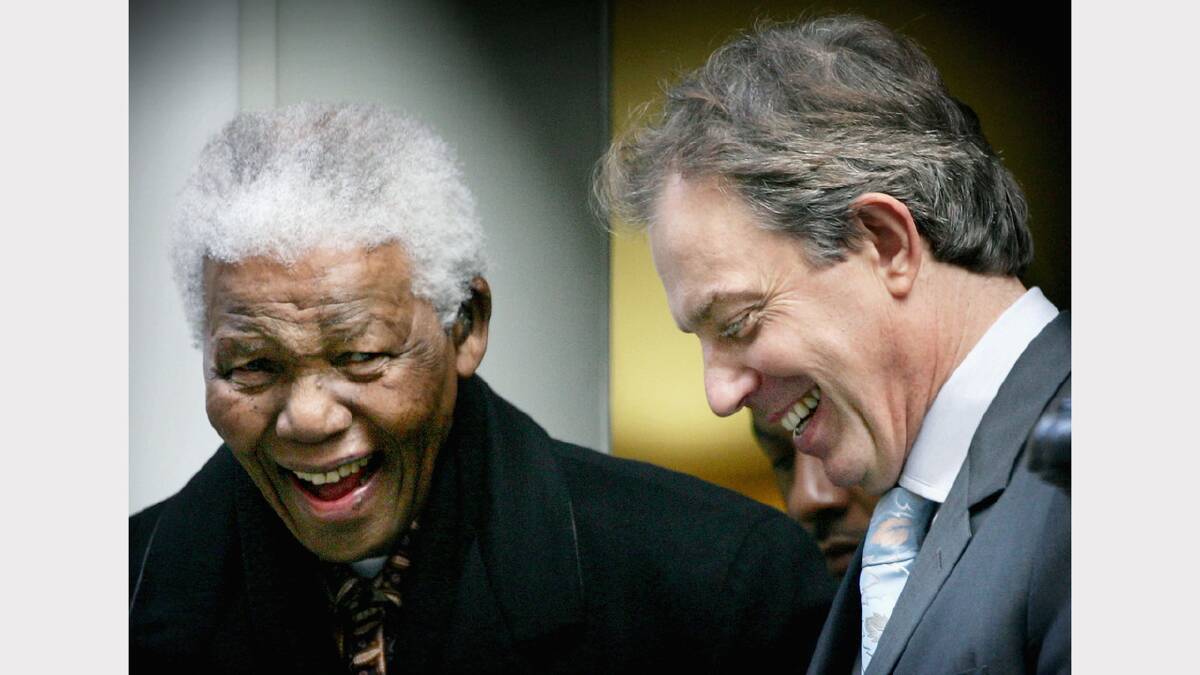 Former President of South Africa Nelson Mandela laughs with British Prime Minister Tony Blair as he leaves Downing Street on November 26, 2004 in London, England. 