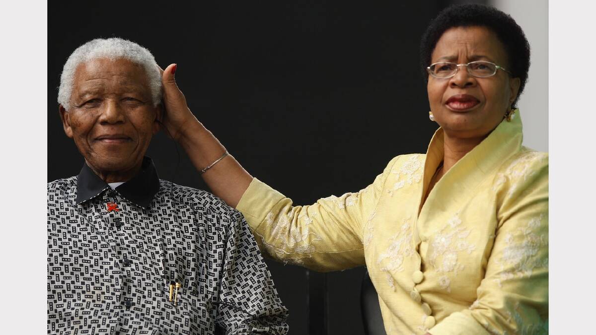 Ex-South African President Nelson Mandela has his head caressed by his wife Graca Machel during a statue unveiling ceremony in his honour at Parliament Square on August 29, 2007 in London, England.