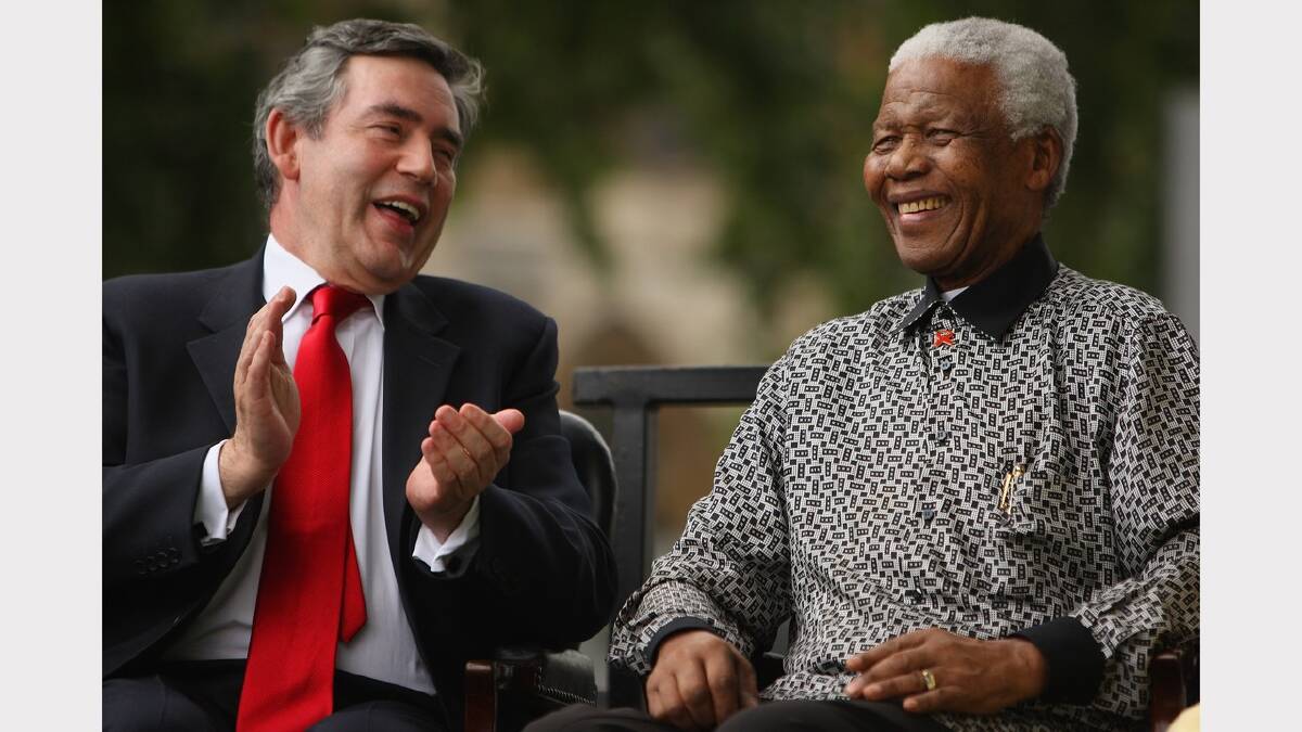  British Prime Minister Gordon Brown applauds ex-South African President Nelson Mandela during a statue unveiling ceremony in Nelson Mandela's honour at Parliament Square on August 29, 2007 in London