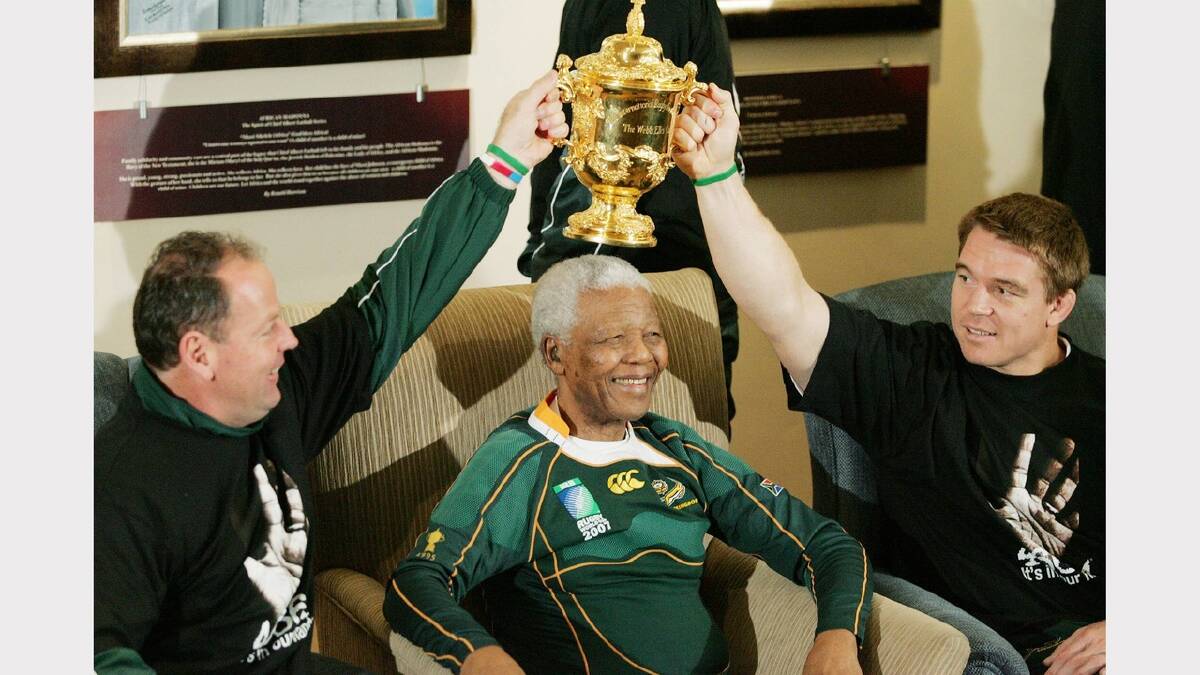 Former South Africa President Nelson Mandela poses with South Africa Rugby Union coach Jake White (L), South Africa Rugby Union captain John Smit (R) and the Webb-Ellis cup during the Springboks visit to Nelson Mandela at his residence on October 27, 2007 in Houghton, Johannesburg, South Africa. 