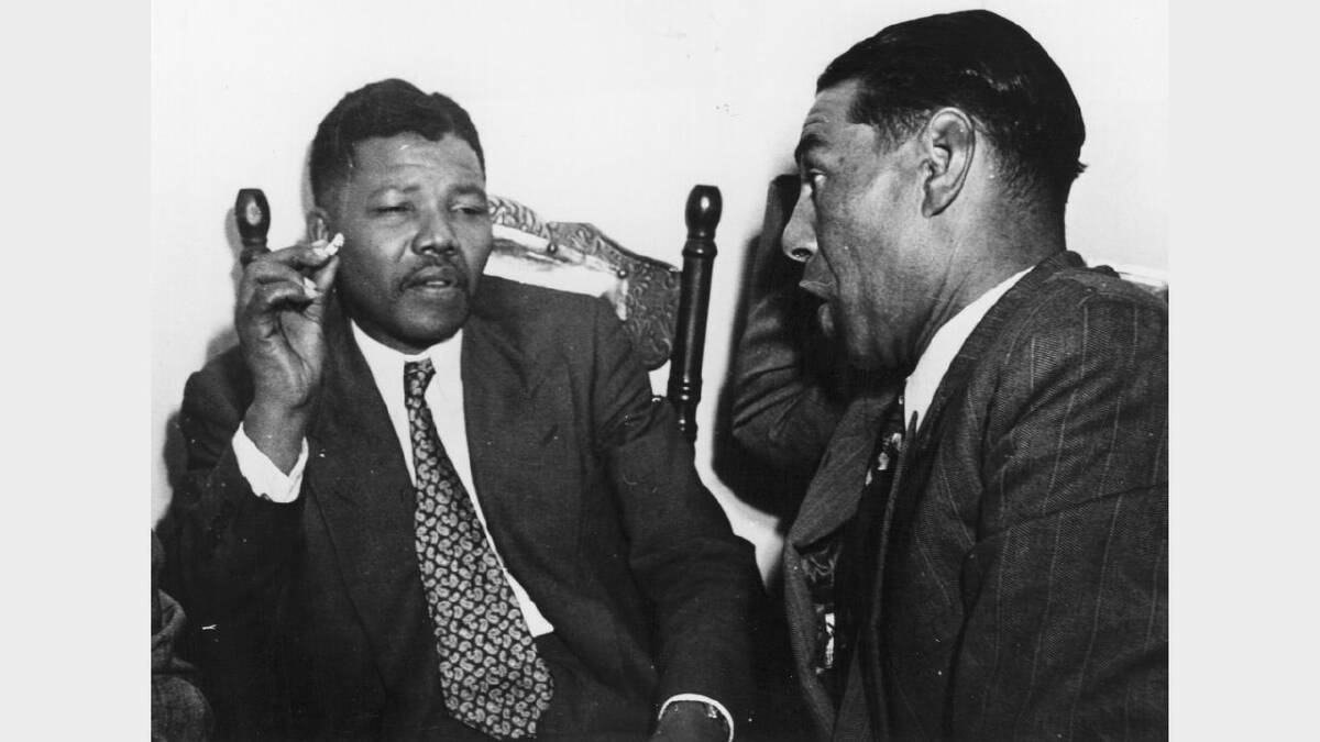 circa 1964: Nelson Mandela, President of the African National Congress (left) in discussion with C Andrews, a Cape Town teacher