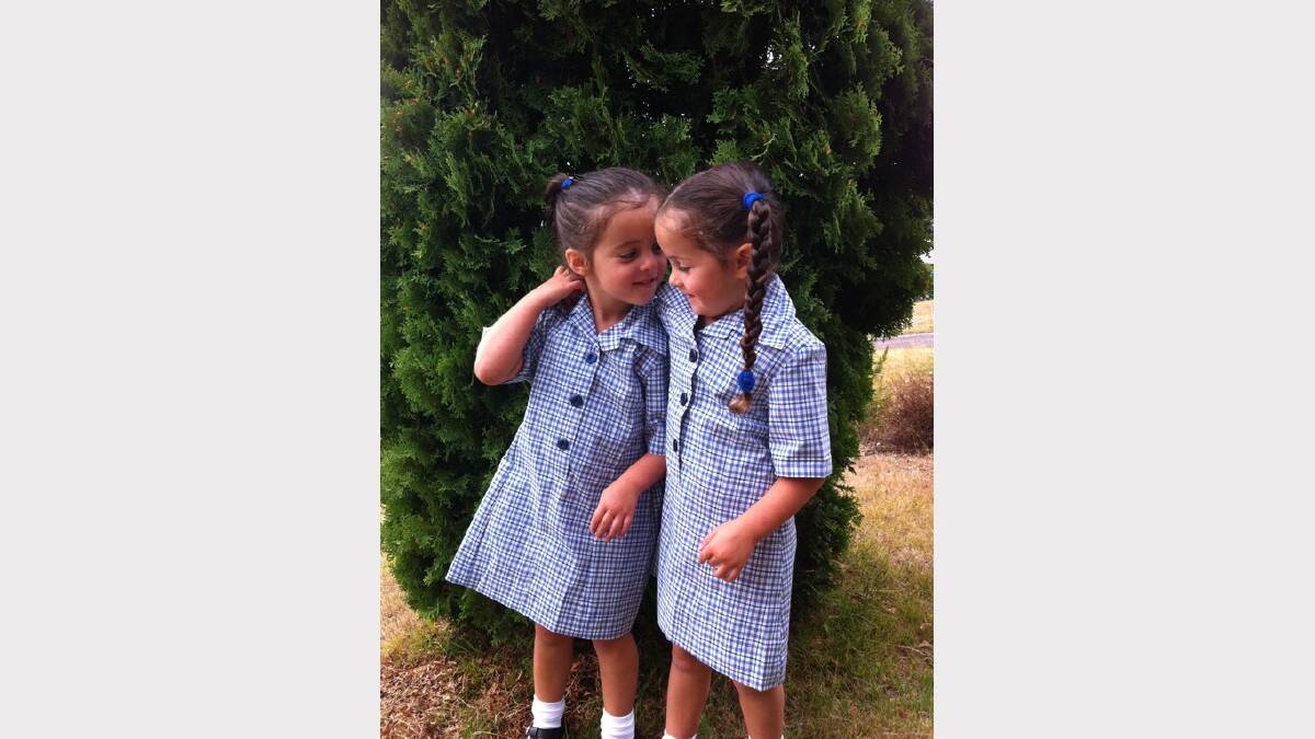 Ingrid (L) and Claudia Schmerl (R) aged 4 have a quick cuddle before heading into their first day at Kinder at St Helens.
