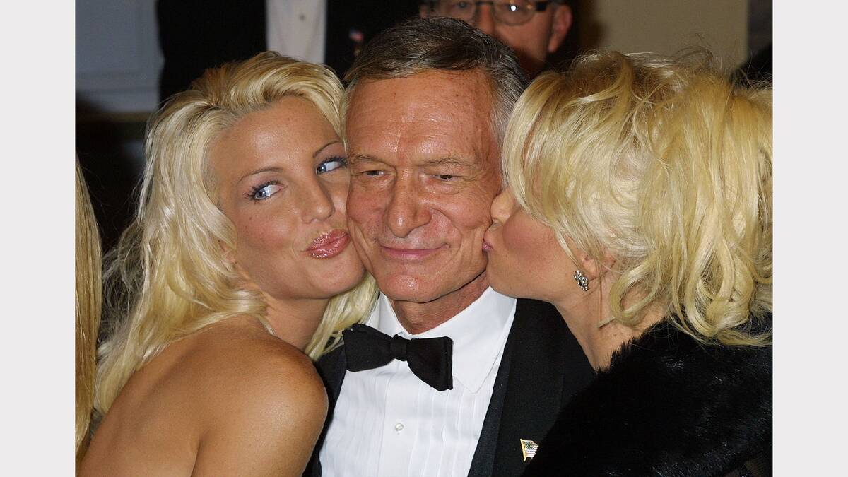 Playboy founder Hugh M. Hefner is gets some kisses from Playboy playmates September 29, 2001 at the Comedy Central and the New York Friars Club Roast in his honor