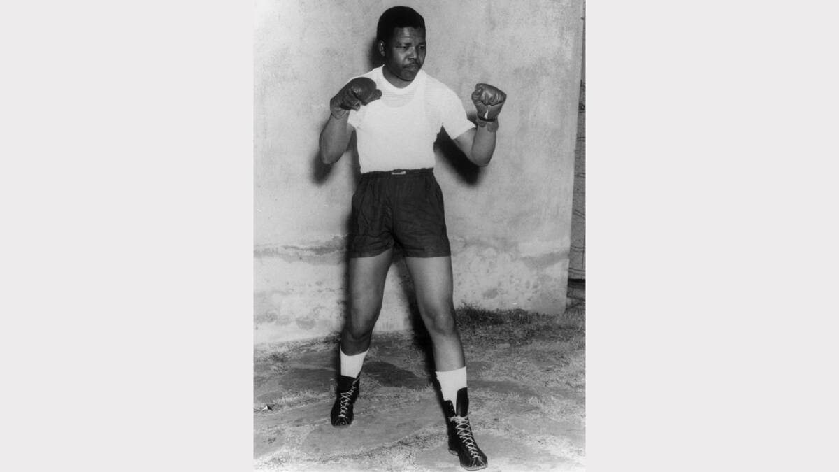 Nelson Mandela, leader of the African National Congress (ANC), adopts a boxing pose, wearing shorts, t-shirt and boxing gloves, circa 1950. (Photo by Keystone/Hulton Archive/Getty Images)	