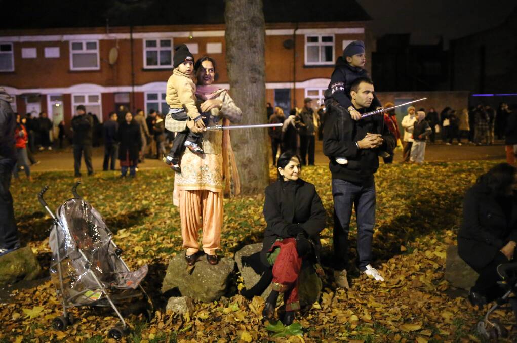 Families and locals gather to watch fireworks during the Hindu festival of Diwali on November 13, 2012 in Leicester, United Kingdom. Up to 35,000 people attended the Diwali festival of light in Leicester's Golden Mile in the heart of the city's asian community. Photo by Christopher Furlong/Getty Images