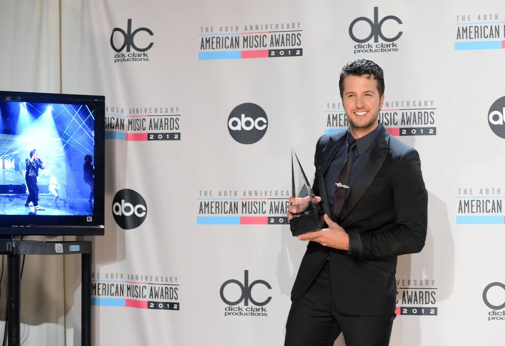 Singer Luke Bryan poses with the Favorite Country Music Male Artist award in the press room at the 40th American Music Awards held at Nokia Theatre L.A. Live in Los Angeles, California. Photo by Jason Merritt/Getty Images