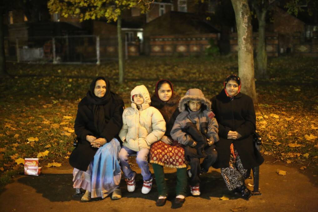A family wraps up against the cold to watch fireworks during the Hindu festival of Diwali on November 13, 2012 in Leicester, United Kingdom.
