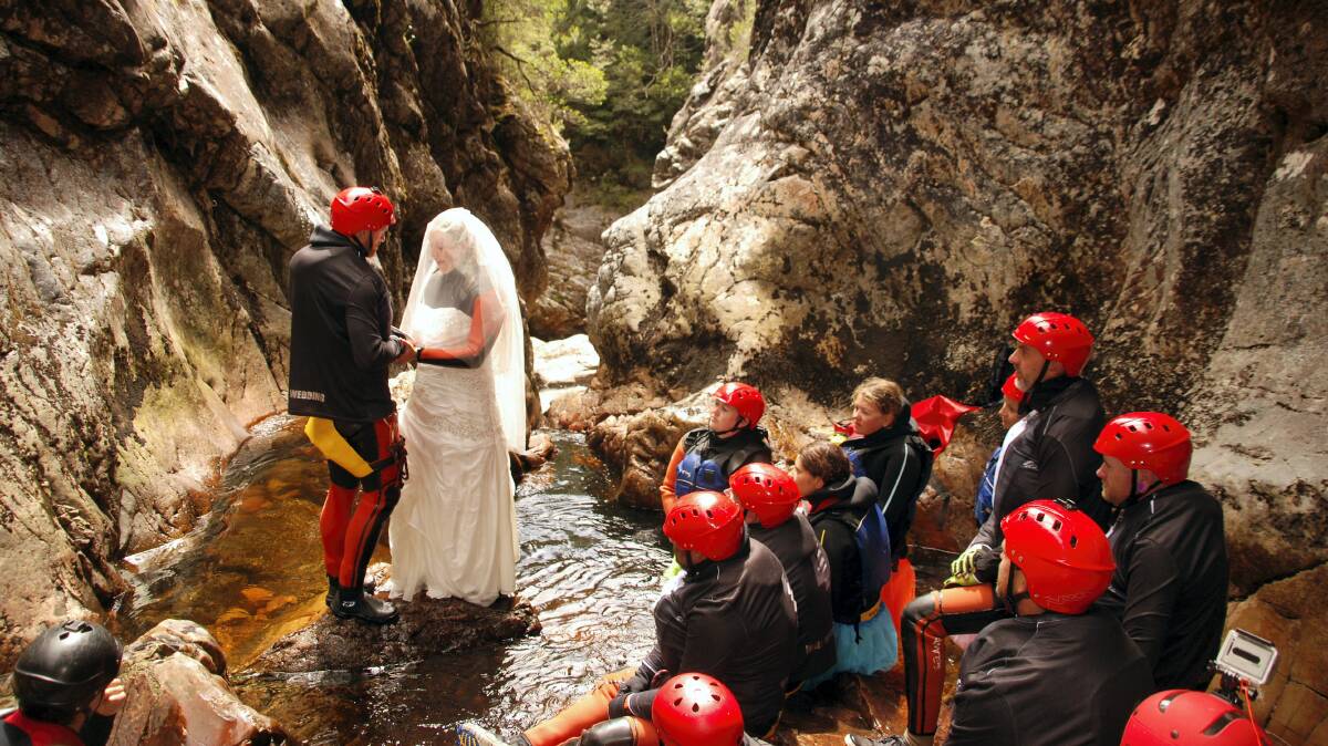 Jarrod Wells and Cassy Austin exchange their wedding vows in the World Heritage Dove Canyon, near Cradle Mountain, yesterday.   A competition run by an adventure tourism company  sparked plans for the unusual wedding.