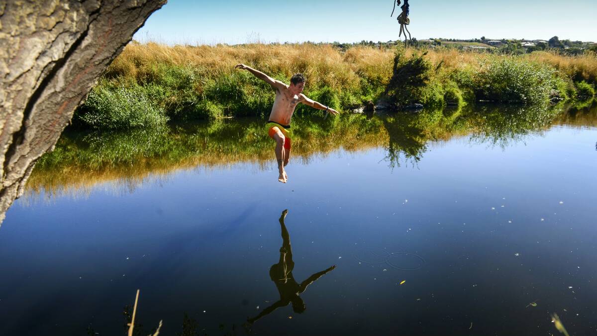 Nathan Barry, of Norwood, takes a leap into the North Esk River at St Leonards yesterday ... summer ends today with temperatures to reach the low to mid-20s.  Picture: PHILLIP BIGGS