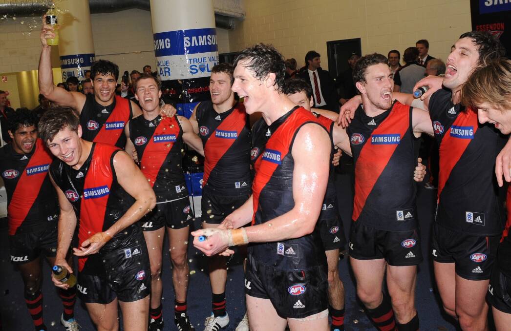 Essendon teammates celebrate a win after a game against the Sydney Swans in 2011.
