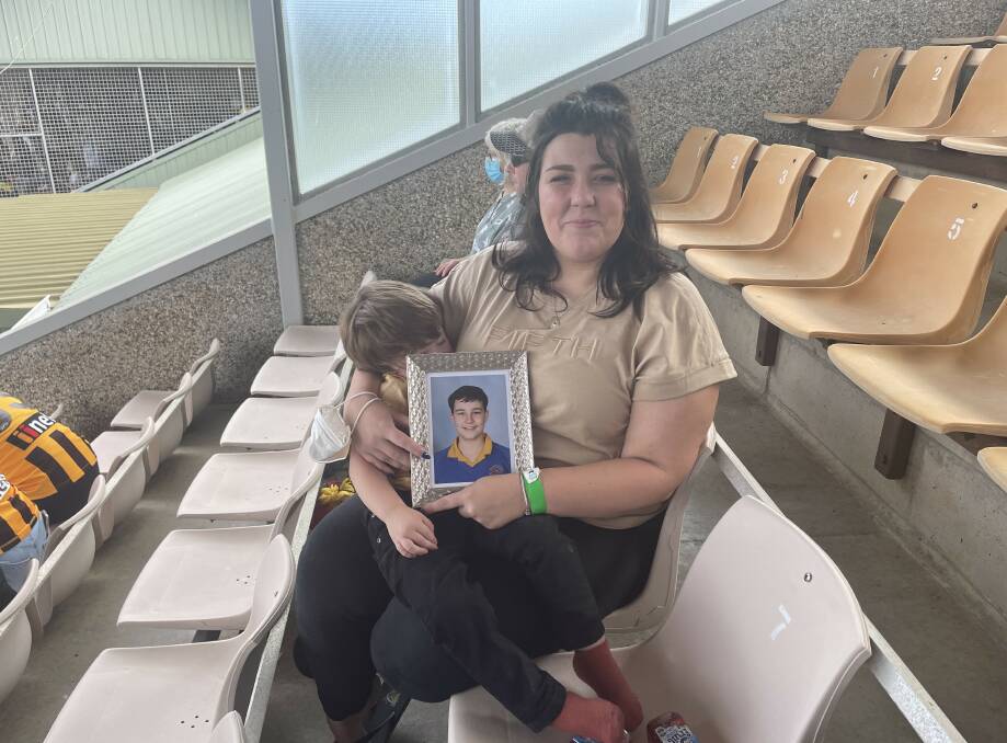 Georgie Gardam, mother of Zane Mellor, watched the game from the stands with a photo of her son beside her. 