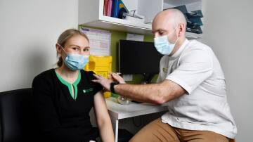 Pharmacist Jack Muir Wilson at Terry White Pharmacy giving dispensary technician Danielle Bracken a flu vaccine. Picture: Brodie Weeding