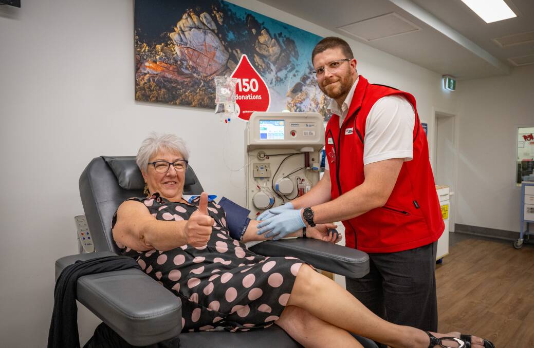 Michele Polley gives a thumbs up for her 150th donation alongside Launceston Lifeblood centre manager Dylan Visser. Picture by Paul Scambler