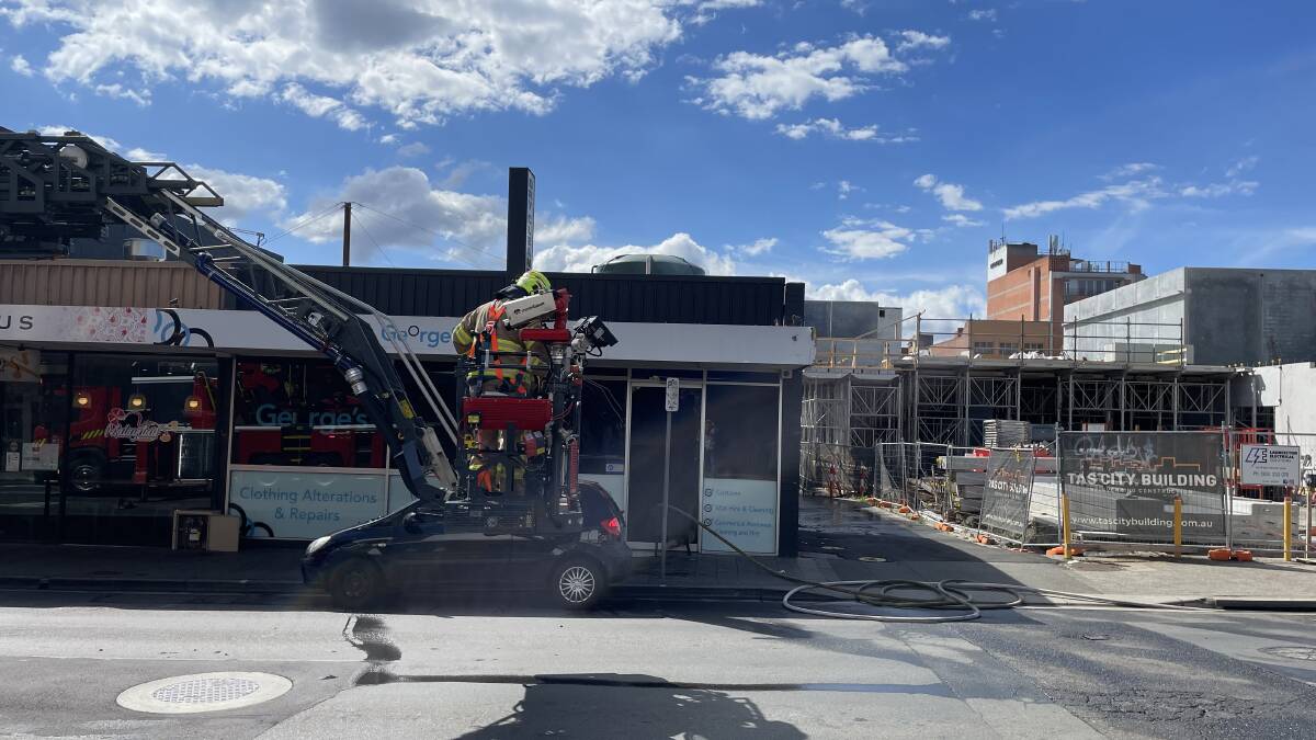 TFS work to contain a blaze at George's Dry Cleaning. Picture by Rod Thompson