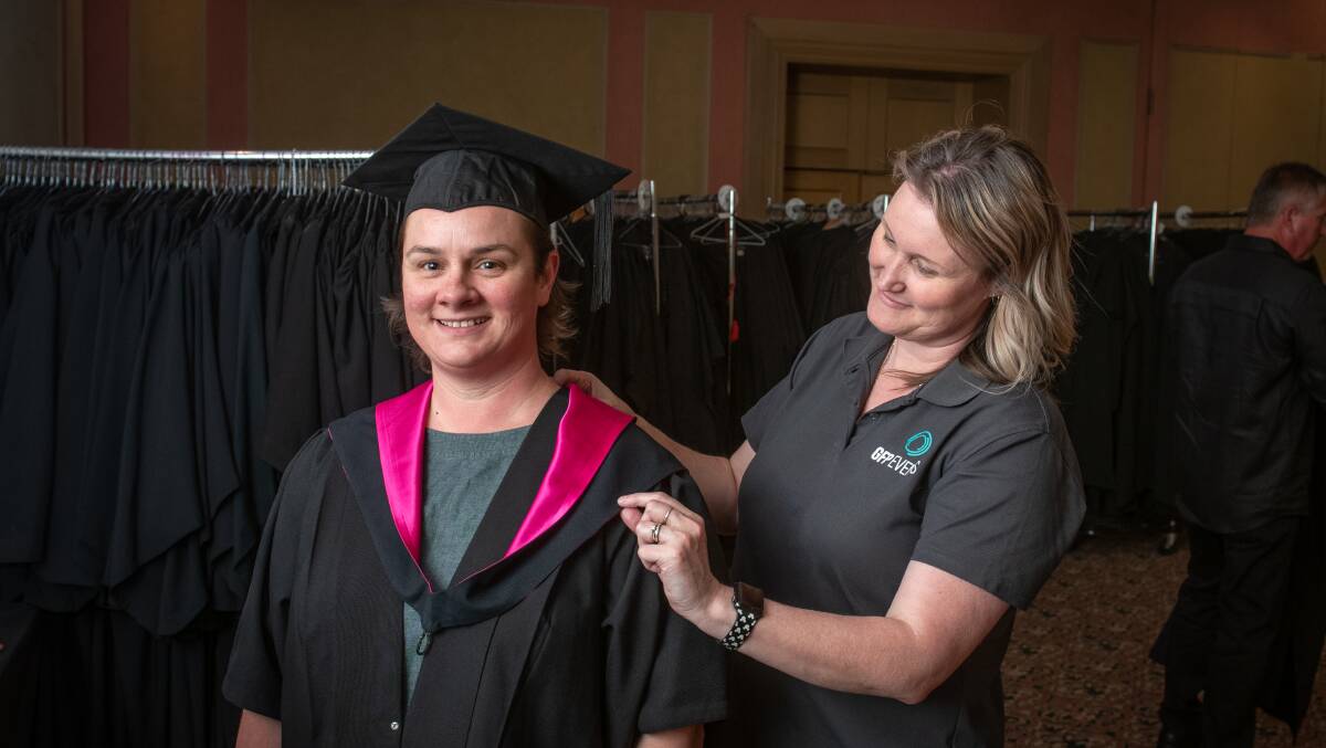 PROUD: Master of Architecture graduand Kylie Harvey tries on her graduation gown with the help from Kristy Jarrett of GFP Events. Picture: Paul Scambler