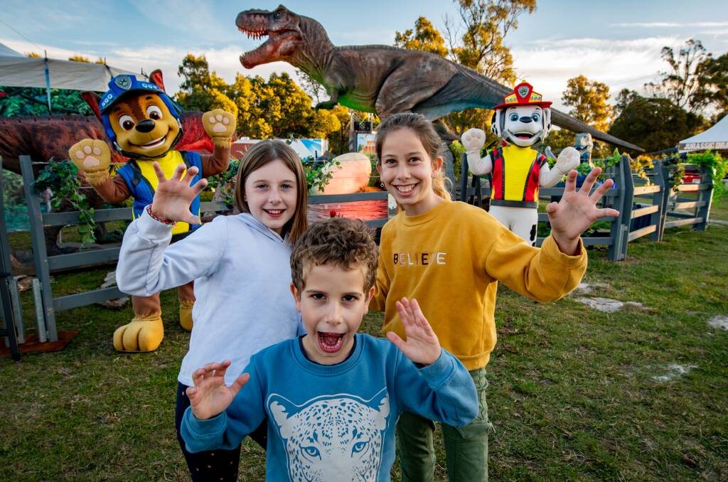 FANS: Eva Nicholls, 9, Yoni Drory, 6, and sister Shyli Drory, 10, with Paw Patrol and T-Rex at the Jurassic Creatures display. Picture: Paul Scambler
