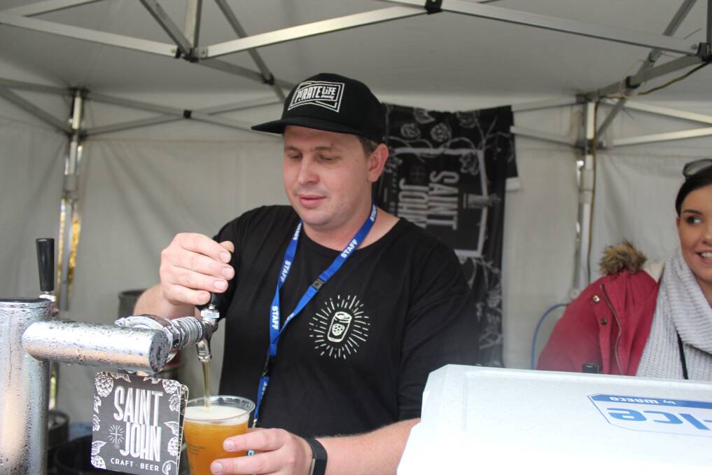 St John Craft Beer co-owner Tim Jarosz pours a beer at a festival in Launceston. He says staff are getting tested today. Picture: Hamish Geale