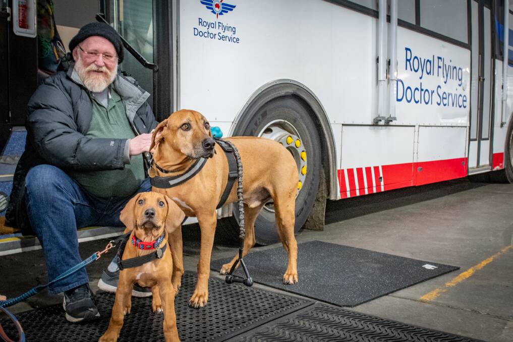 SOLID EFFORT: Former RFDS chief executive John Kirwan with his dogs Louis and Indigo at the RFDS hangar in Launceston. Picture: Paul Scambler