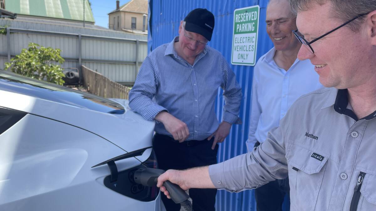 Nathan Bourke shows Roger Jaensch and Nick Duigan how to charge an electric vehicle. Picture by Rodney Woods