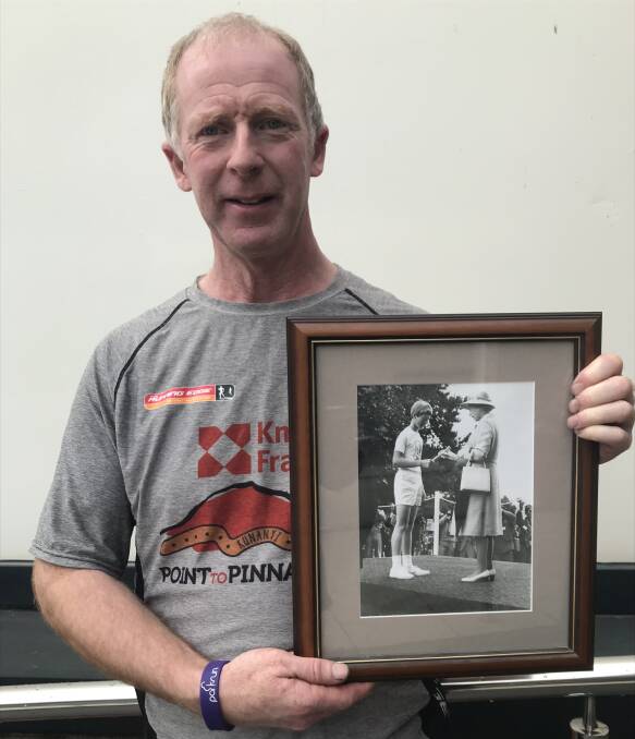Andrew Page with a photo of his younger self greeting the Queen in Hobart in 1977. Picture supplied.