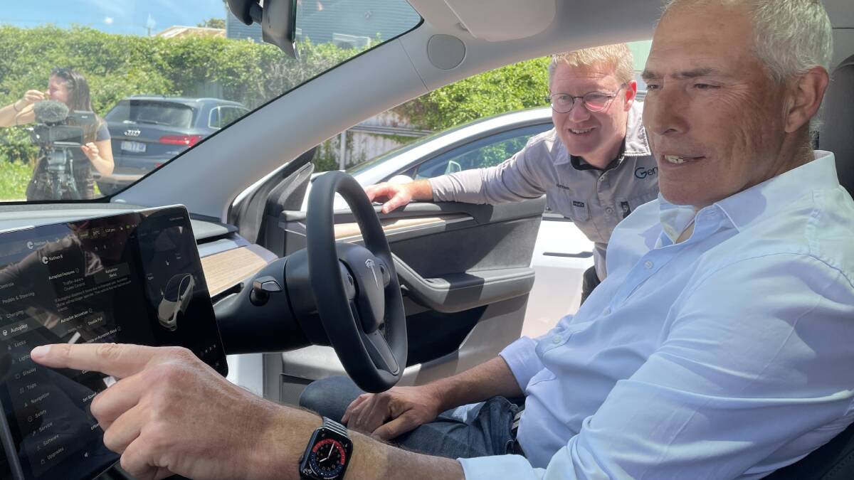 Renewables Minister Nick Duigan tests out a Tesla with the help of Genr8 Electrical director Nathan Bourke. Picture by Rodney Woods